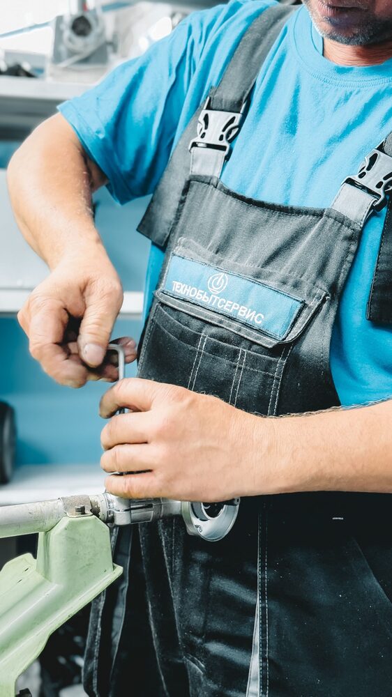 Plumber repairing a pipe with a wrench